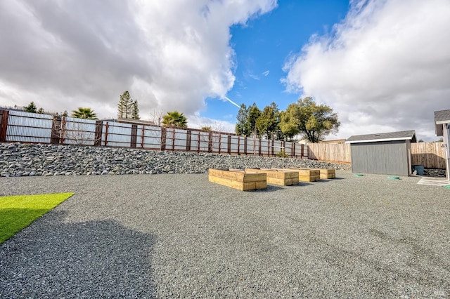 view of yard featuring an outbuilding, a storage unit, and a fenced backyard