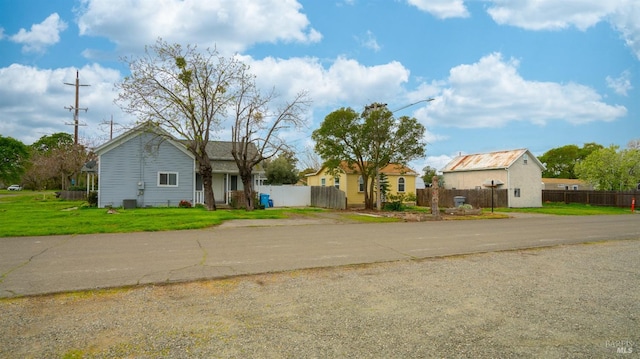 view of front of home featuring fence and a front lawn