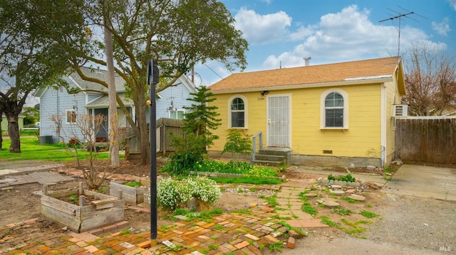 view of front facade with crawl space, fence, and a garden