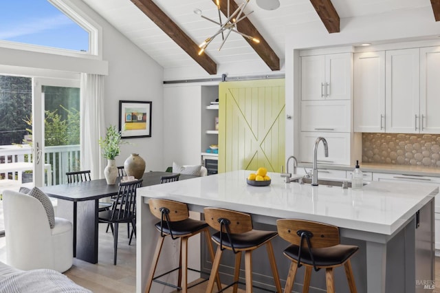 35 Bernard St, Mill Valley, CA 94941 - kitchen featuring a barn door, white cabinetry, a breakfast bar, and a sink