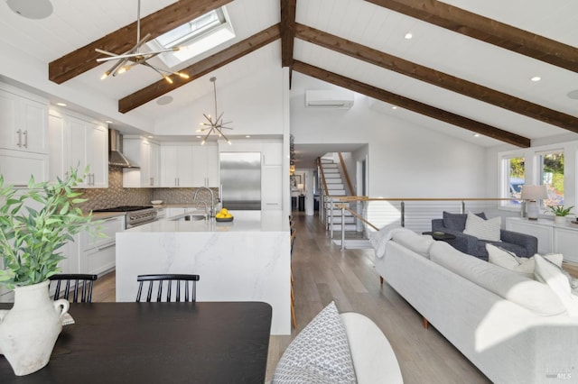 35 Bernard St, Mill Valley, CA 94941 - living room featuring a wall mounted AC, beamed ceiling, light wood-style floors, stairway, and a skylight