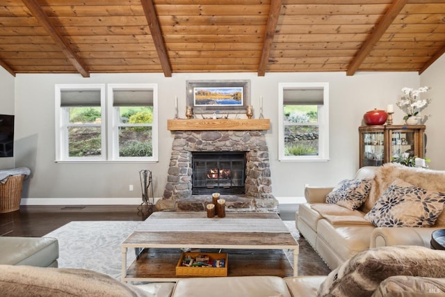 living area with wood ceiling, lofted ceiling with beams, wood finished floors, a stone fireplace, and baseboards