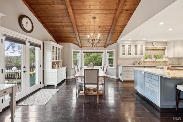 dining area with dark wood finished floors, baseboards, lofted ceiling with beams, and a chandelier