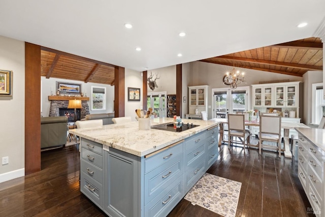 kitchen with vaulted ceiling with beams, open floor plan, gray cabinets, and wood ceiling