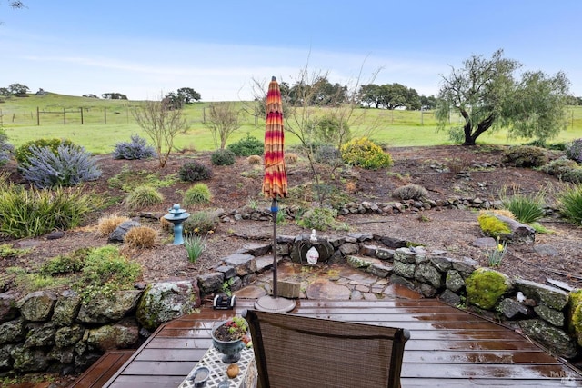 view of yard with fence and a rural view