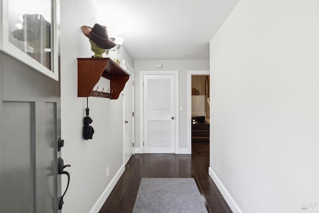 hallway with baseboards and wood finished floors