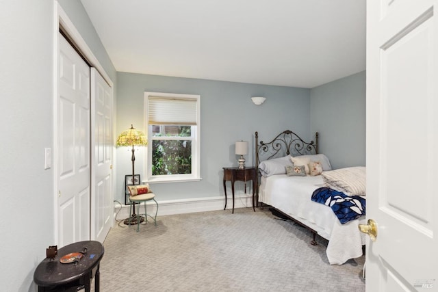 bedroom with carpet floors, baseboards, and a closet