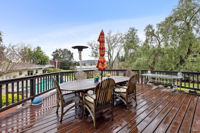 wooden deck featuring an outdoor pool and outdoor dining space