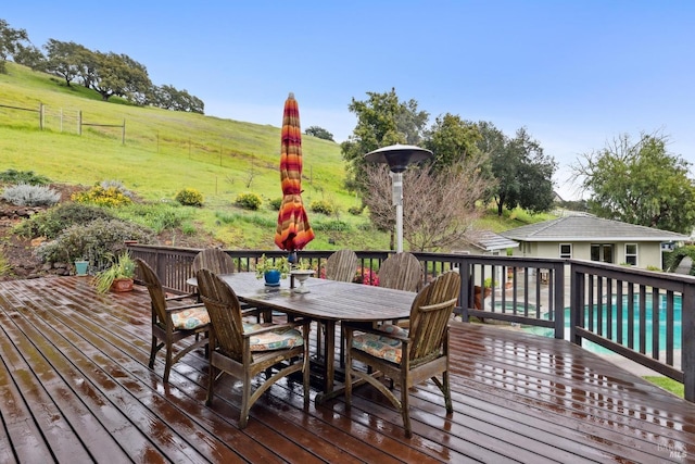 wooden deck featuring a lawn and outdoor dining space