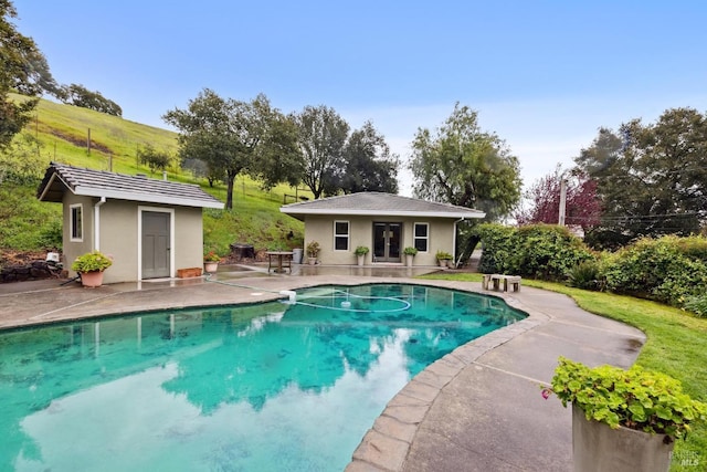 pool with an exterior structure, french doors, an outdoor structure, and a patio area