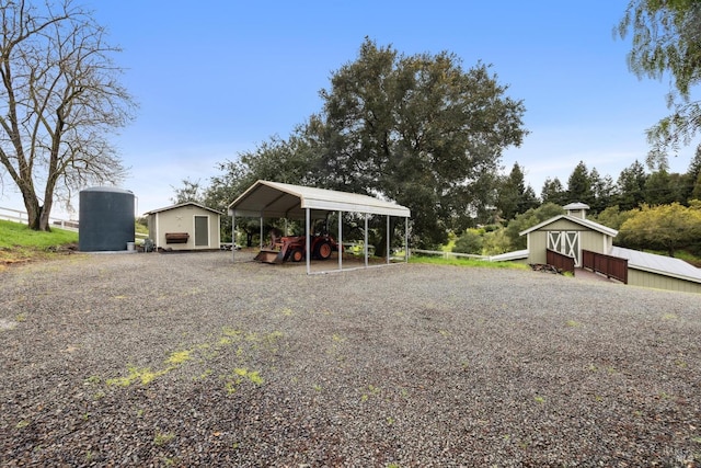 view of yard with gravel driveway, an outbuilding, a shed, and a detached carport