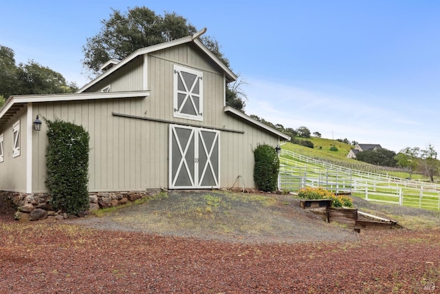 view of barn featuring fence