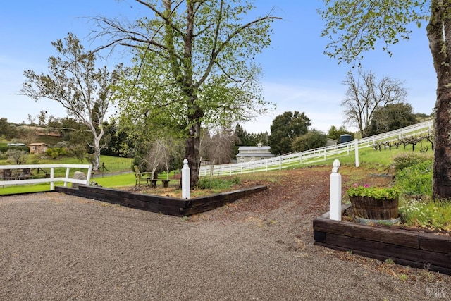 surrounding community with fence and a rural view