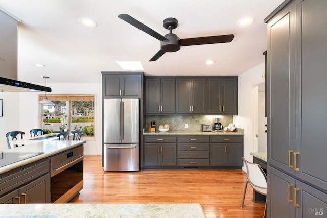 1777 Adams St, Saint Helena, CA 94574 - kitchen featuring ceiling fan, wall chimney exhaust hood, appliances with stainless steel finishes, light wood finished floors, and decorative backsplash