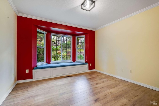 empty room with light wood-type flooring, ornamental molding, and visible vents