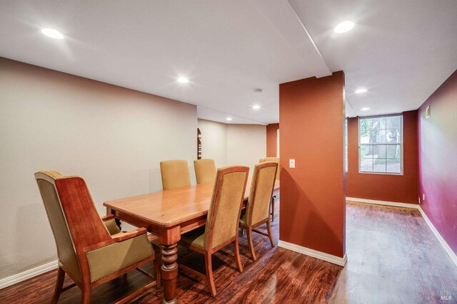 dining room with baseboards, wood finished floors, and recessed lighting