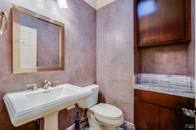half bathroom featuring a sink and toilet