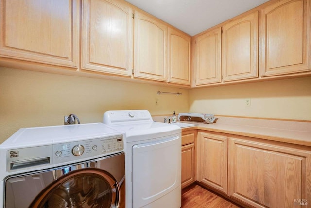 laundry room featuring cabinet space, independent washer and dryer, and light wood-type flooring