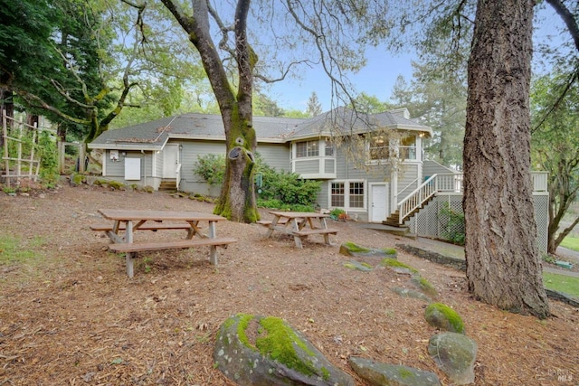 rear view of property with stairs and a deck
