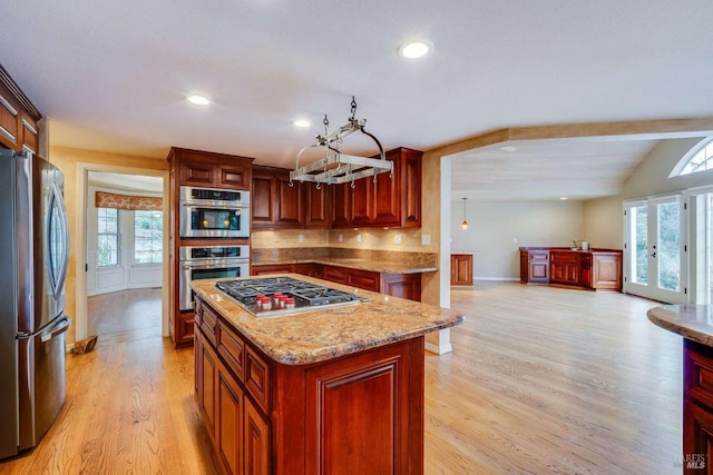 kitchen with light stone counters, stainless steel appliances, light wood-style floors, recessed lighting, and dark brown cabinets