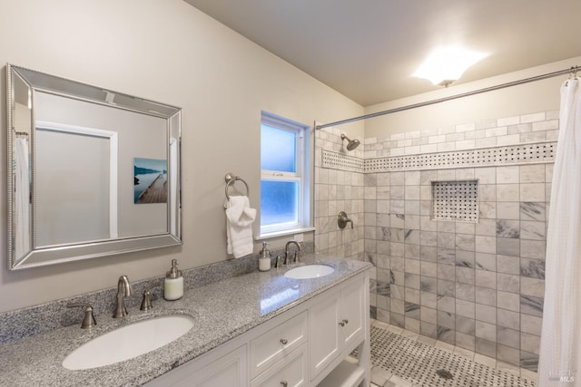 bathroom featuring double vanity, a sink, and a tile shower