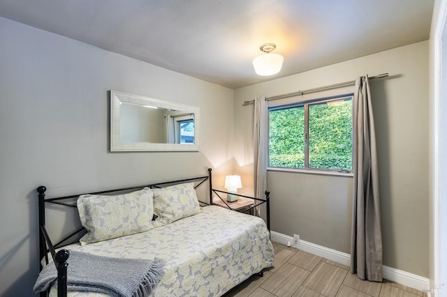 bedroom with baseboards and wood tiled floor