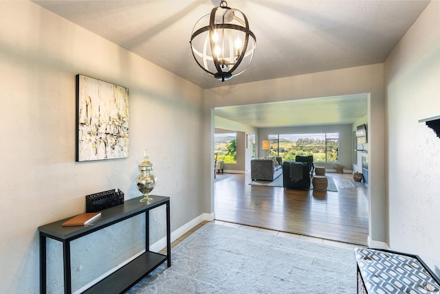 foyer entrance featuring baseboards and a notable chandelier