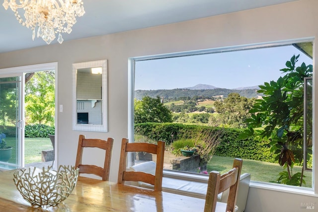 entryway featuring an inviting chandelier, a mountain view, and wood finished floors