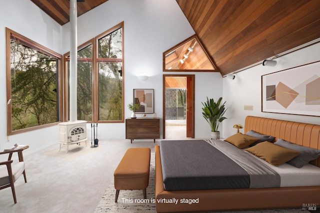 bedroom with wooden ceiling, a wood stove, multiple windows, and carpet flooring