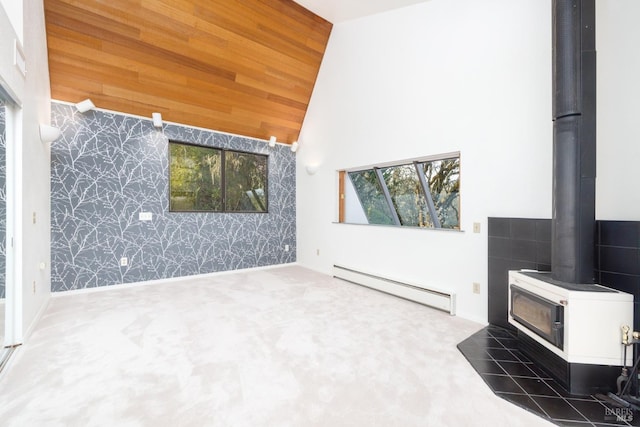 unfurnished living room with wallpapered walls, carpet, a wood stove, a baseboard heating unit, and high vaulted ceiling