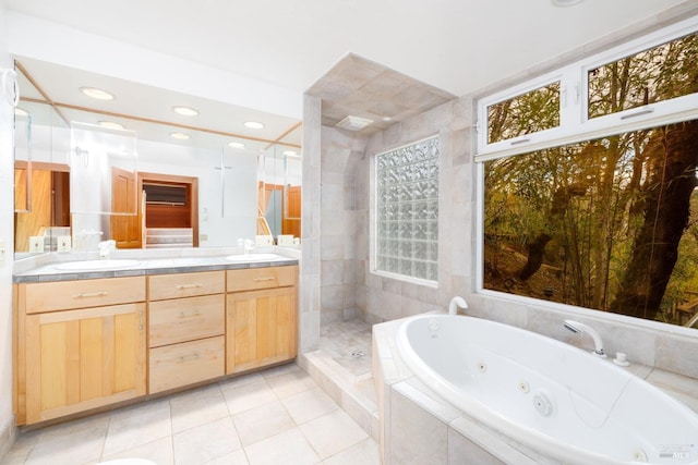 bathroom with tile patterned floors, a jetted tub, a sink, and double vanity