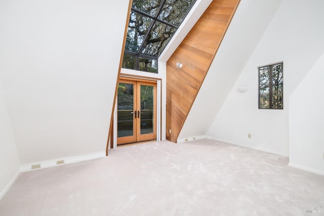 spare room with french doors, carpet flooring, and a high ceiling