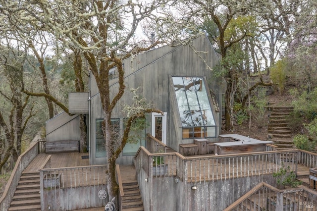 view of property exterior with a wooden deck and stairs