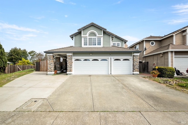 traditional-style home with a tiled roof, driveway, fence, an attached garage, and stone siding