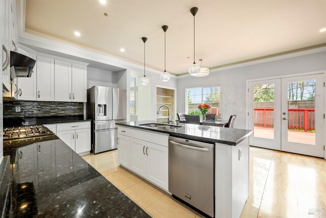 kitchen featuring appliances with stainless steel finishes, ventilation hood, a sink, decorative backsplash, and ornamental molding