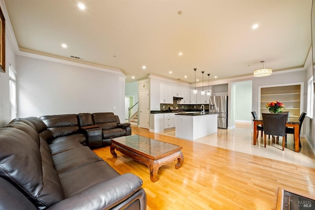 living room featuring visible vents, recessed lighting, and ornamental molding