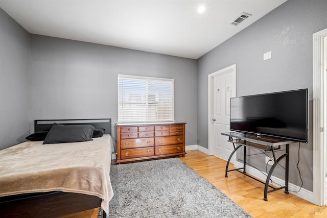 bedroom featuring visible vents, baseboards, and wood finished floors