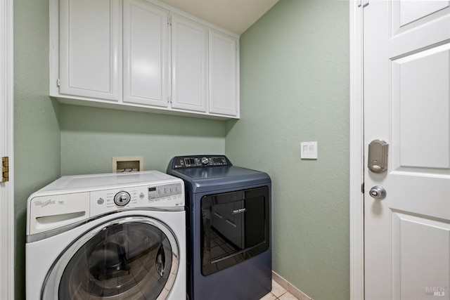 laundry area with baseboards, cabinet space, light tile patterned floors, and washing machine and dryer