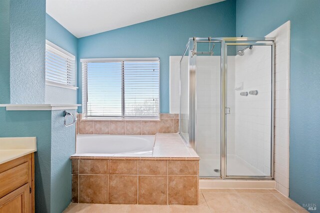 bathroom with vaulted ceiling, vanity, tile patterned flooring, and a stall shower