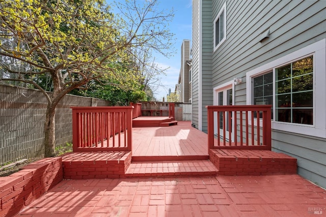 wooden deck with a fenced backyard and a patio area