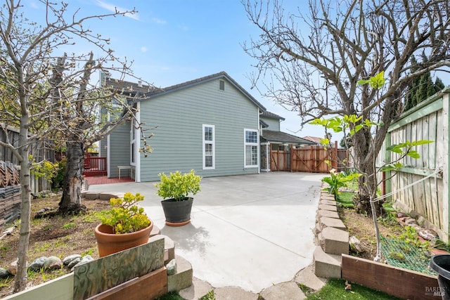 rear view of house with a patio and a fenced backyard