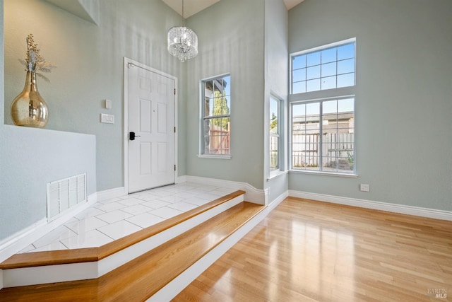 foyer featuring plenty of natural light, a high ceiling, and visible vents