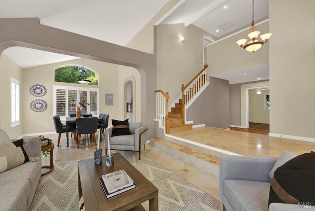 living room featuring stairs, arched walkways, baseboards, and light tile patterned floors