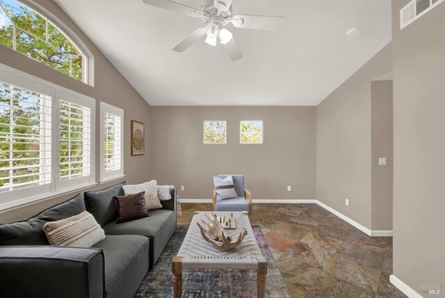 living area with baseboards, lofted ceiling, ceiling fan, and visible vents