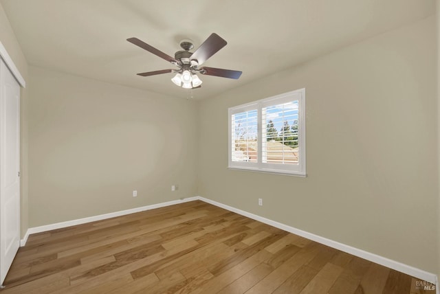 empty room featuring baseboards, light wood finished floors, and ceiling fan