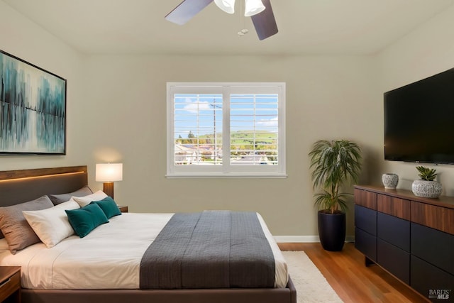 bedroom with baseboards, ceiling fan, and wood finished floors