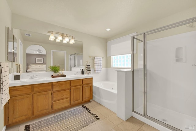 full bathroom featuring a stall shower, tile patterned floors, a sink, a garden tub, and double vanity
