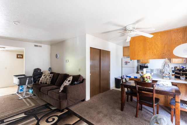 living area featuring carpet floors, ceiling fan, and visible vents