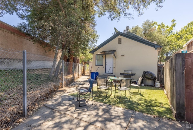 back of property featuring a fenced backyard, stucco siding, a patio area, and a yard