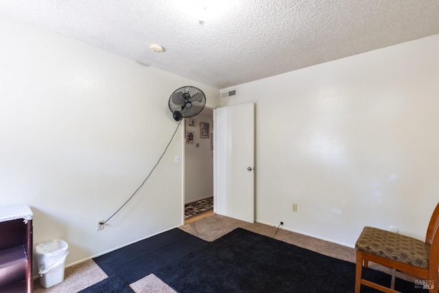 interior space with baseboards, visible vents, carpet, and a textured ceiling